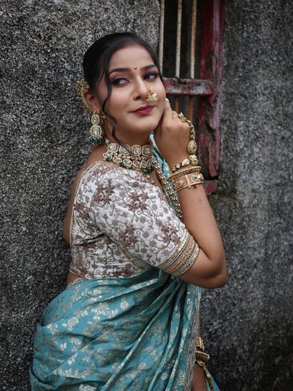 A side profile showcasing the floral embroidered blouse paired with the blue Nauvari.