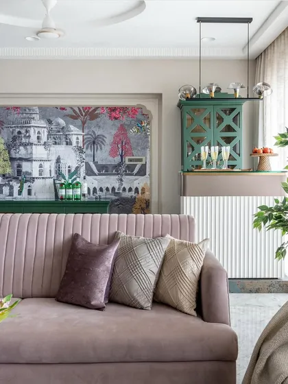 This living room is a celebration of color and pattern. The mauve sofa provides a soft, inviting base, while the striking wallpaper and green bar cabinet add layers of personality and a touch of eclectic charm.