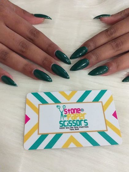 This deep, forest green color is stunning and unique. A solid color manicure like this on sharp stiletto nails makes a powerful and fashionable statement.