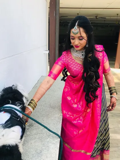 The bride taking her furry friend for a walk before the event. Her makeup is fresh and ready for the day's festivities.
