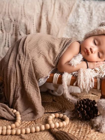 This little one is in one of our dreamiest setups. I love using miniature props like this wooden bed to create a sense of scale and whimsy.