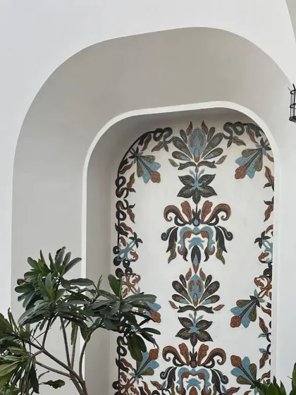 The finished mosaic fresco nestled within an architectural arch, creating a beautiful focal point in the courtyard.