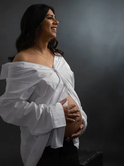 A solo portrait filled with happiness. The off-the-shoulder white shirt gives this black and white shot a casual yet chic vibe, focusing on her joyful glow.