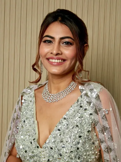 A smiling portrait of this stunning client. The full-glam silver makeup and diamond jewelry create a look of pure radiance.