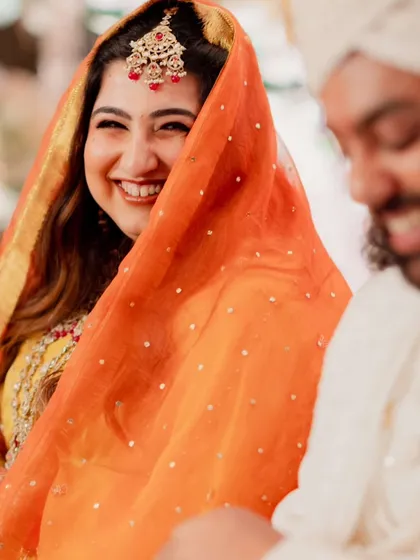 Capturing the joy of this bride's wedding ceremony. Her makeup is traditional and radiant, with warm tones and defined eyes, paired with soft waves for a look that is both classic and effortlessly beautiful.