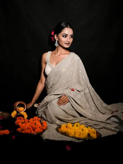 This shot combines traditional elements with a graceful pose. The marigold flowers and brass pot add an authentic touch to this beautiful festive portrait.