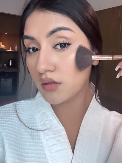A close-up of me applying highlighter, a key step in any glowing makeup look.