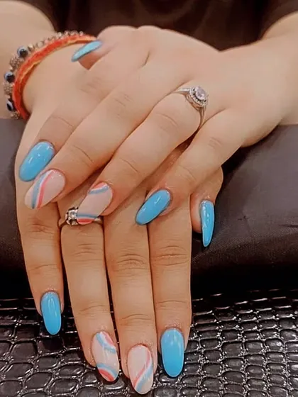 For a fun and modern look, I combined solid sky blue gel polish with a negative space swirl design on these oval-shaped nail extensions. This style is perfect for anyone who wants a pop of color with an artistic touch.