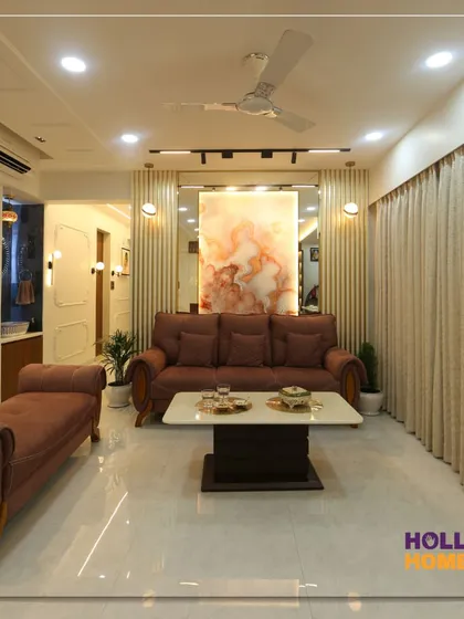 A wide view of the living and dining area, showing how we integrated a comfortable lounge space with a chaise, a modern sofa set, and a dedicated wash basin area with decorative niches.