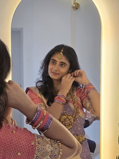 A moment of reflection. Laasya getting ready, her pastel saree and traditional jewelry creating a look of soft, feminine grace.