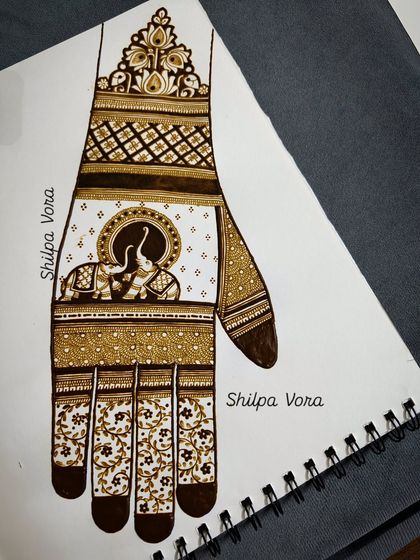 This is a practice sheet where I've sketched a full hand design featuring elephants. We use these templates to perfect complex compositions before trying them on skin.