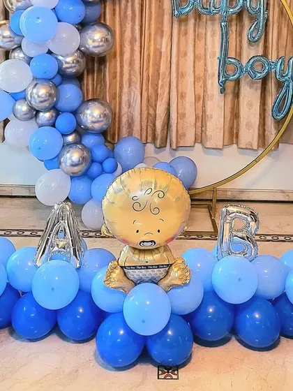 A close-up of the 'BABY' letter balloons and baby foil balloon centerpiece.