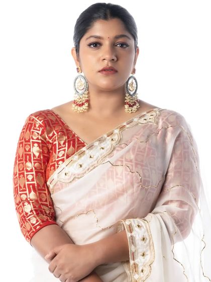 A frontal shot of Aparna Balamurali, showing the neatness of the shoulder pleats and the overall balance of the drape.