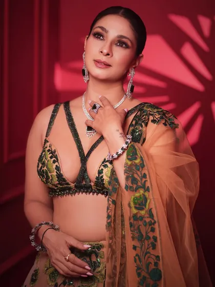 A close-up portrait that captures a sense of grace and confidence. The focus is on her expressive eyes and the beautifully coordinated jewelry.