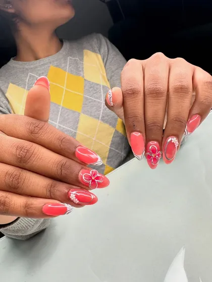 Student work featuring a stunning coral-colored set with delicate white outlines and a beautiful 3D flower accent.