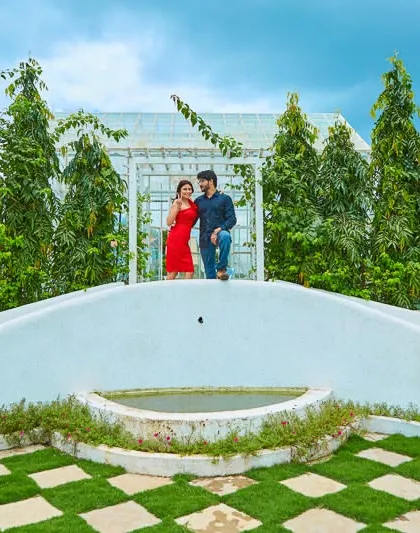 The clean lines and lush greenery of our white bridge set provide a modern and symmetrical backdrop for a stylish couple portrait.