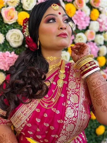 A candid moment capturing the bride's radiant reception look. The upward glance highlights the detailed eye makeup and the beautiful contouring that defines her features.