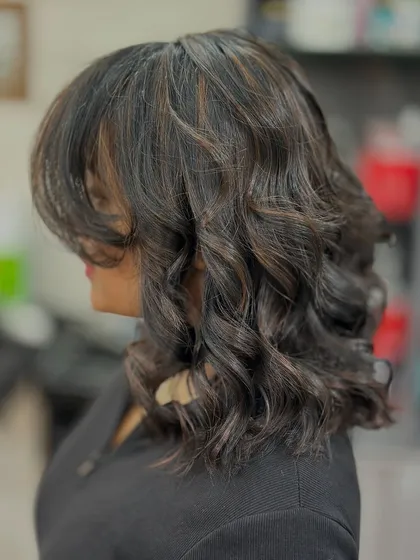 A beautiful copper light brown highlight on shorter, curly hair. This shows that highlights can add amazing dimension to any hair length.