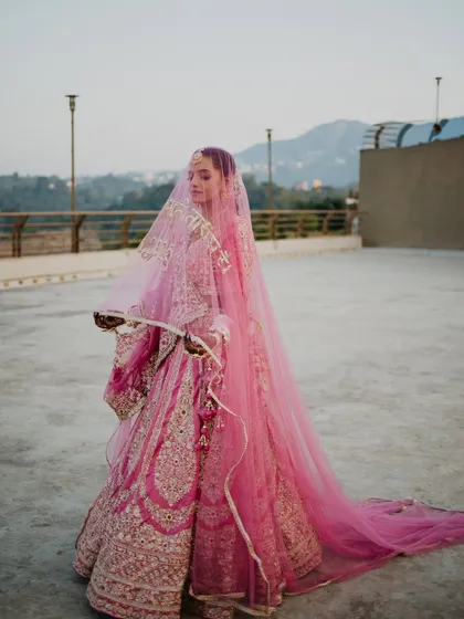 The bride's entry is a moment of pure grace and anticipation. Here, the long veil and the mountain backdrop create a breathtakingly beautiful and serene bridal portrait, capturing her elegance as she walks towards her future.