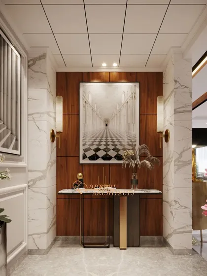This elegant foyer uses a combination of marble and wood paneling to create a luxurious and welcoming entrance, with artwork providing a captivating focal point.
