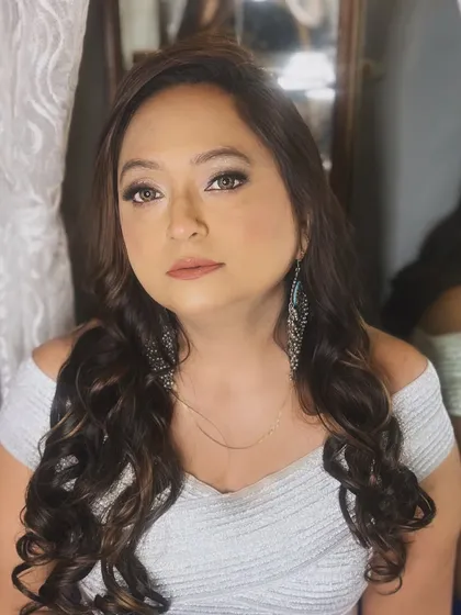 A simple and elegant portrait from a party makeup session. The makeup is soft and glowing, with beautiful, loose curls in her hair.