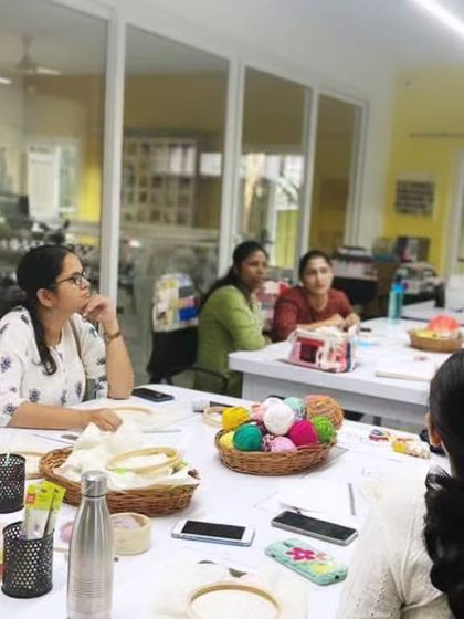 Here I am, explaining the nuances of punch needle fabric and tools to an attentive group. I make sure everyone understands the fundamentals before they start their projects.