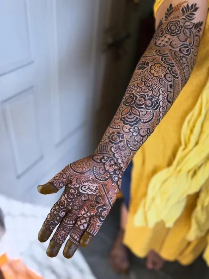 A beautiful Indo-Arabic design with a mix of floral and geometric elements. The sunlight really brings out the rich color of the fresh henna.
