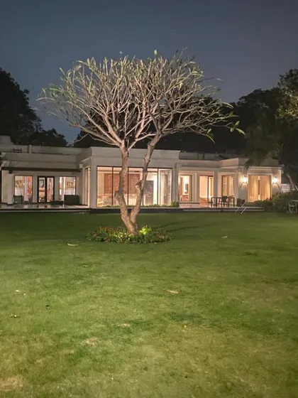 This is one of our farmhouse projects, viewed from the expansive lawn at dusk. We design homes that harmonize with their natural surroundings, using clean architectural lines and large glass panels to create a constant connection to the landscape. The strategic exterior lighting highlights the structure, creating a warm and welcoming beacon.