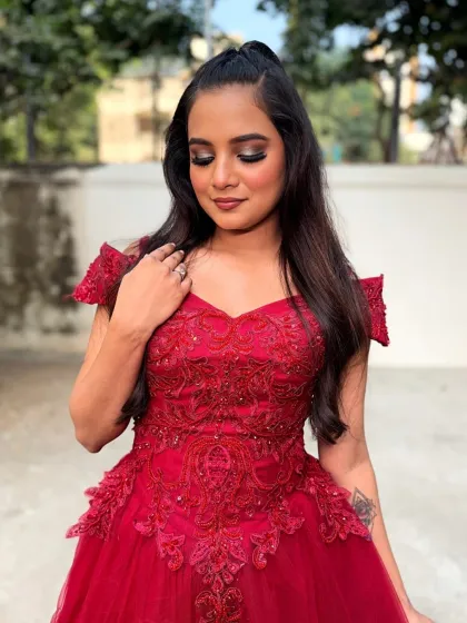 A bold and beautiful look in a red gown. The makeup features a dramatic smokey eye, perfect for a cocktail party or reception.