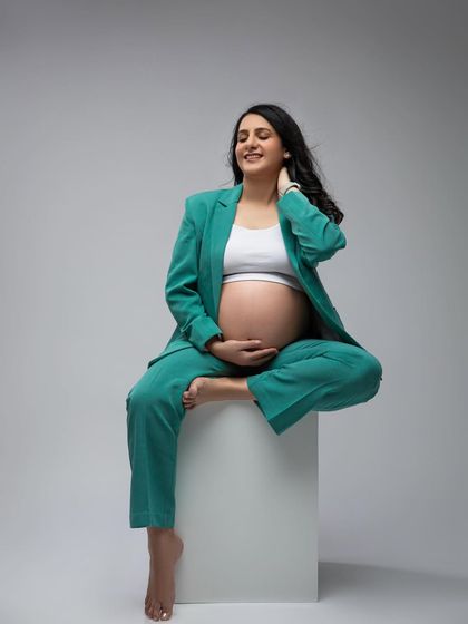 A serene moment in the modern green pantsuit. This outfit is perfect for the mom-to-be who wants a chic, contemporary, and comfortable look.