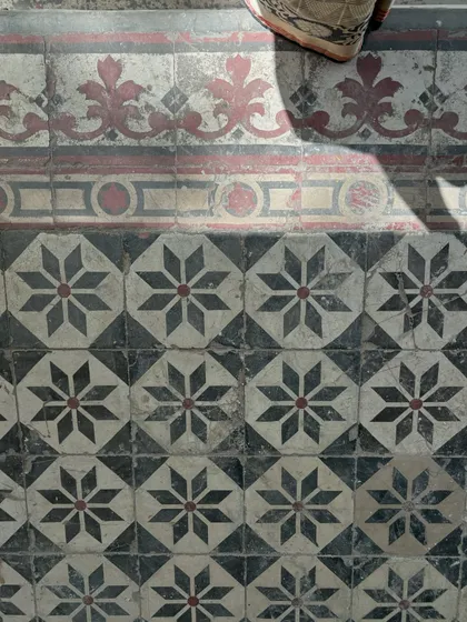 The soul of a building is in its details. We painstakingly preserve and restore original features like these beautiful geometric floor tiles in a classic Delhi house. This commitment to craftsmanship ensures the building's story and character endure.
