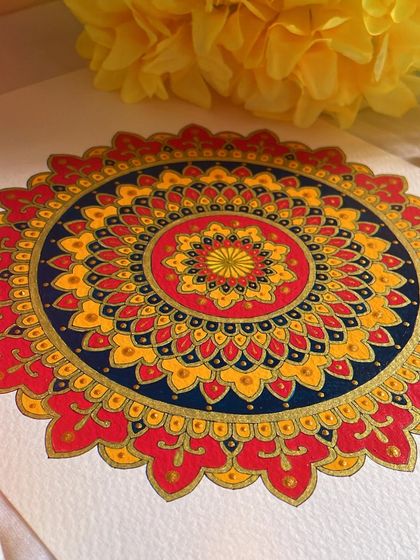 It’s always a bliss to have mandalas around you. This piece uses a warm, fiery palette of red, orange, and yellow, balanced with a deep blue. The gold accents make the colors truly sing.