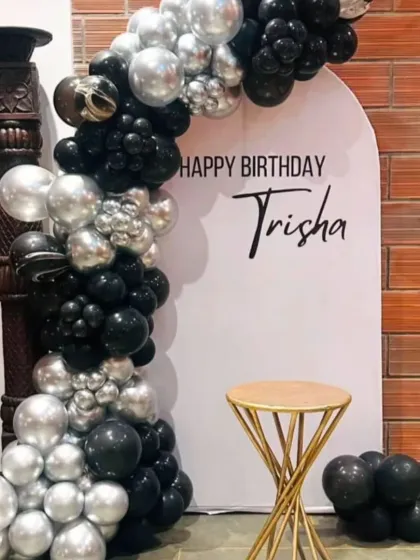 For a sleek and modern birthday celebration, I designed this black and silver balloon arch against a clean white backdrop. I also added a custom vinyl name decal for a personal touch, making it a great photo spot.