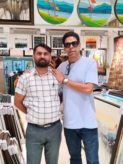 Actor Murli Sharma posing in our gallery, which is filled with a diverse collection of paintings and framing choices.