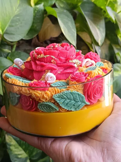 My Rose Garden Jar Candle is a true work of art. This large glass jar is filled with an intricate arrangement of wax roses and leaves, with a large central bloom dusted with gold leaf for a touch of luxury.