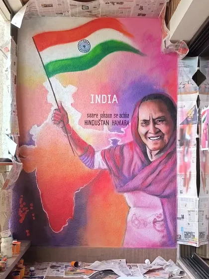 The full view of the patriotic mural during the process, with newspapers protecting the surrounding area. It shows the scale and effort involved.