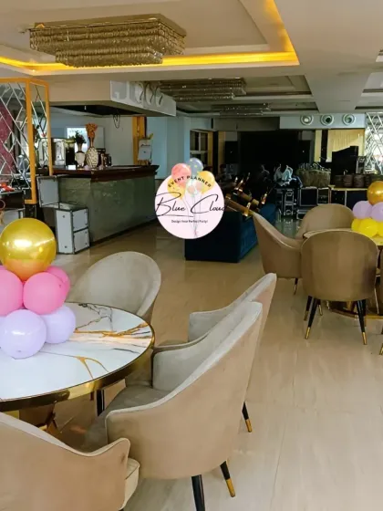 Pastel balloon centerpieces on tables in a modern restaurant setting.