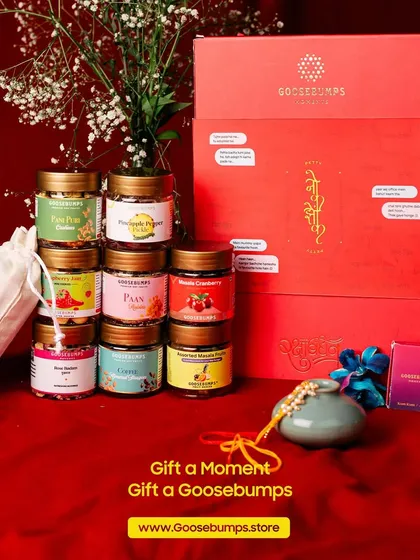 This is the complete 'Nok Jhok' Raksha Bandhan experience. You can see the beautiful gift box, the variety of artisanal snacks inside, and the special pouch of free gifts that comes with every order.