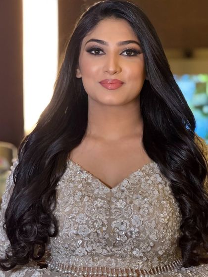 A smiling portrait of the client, looking confident and beautiful in her reception attire.