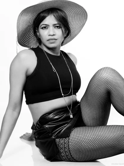 A chic black and white portrait featuring a wide-brimmed hat and layered necklaces. This image has a timeless, high-fashion feel.