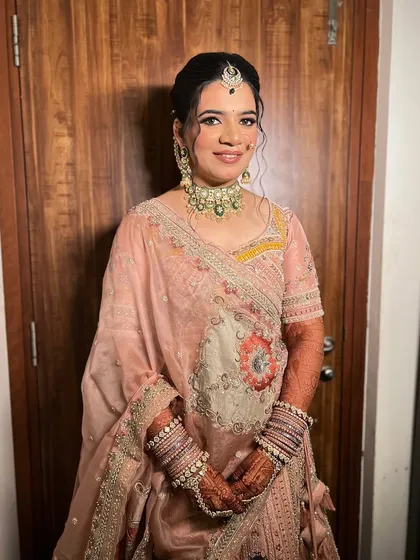 A full shot of the bride in her pastel wedding lehenga, looking elegant and poised.