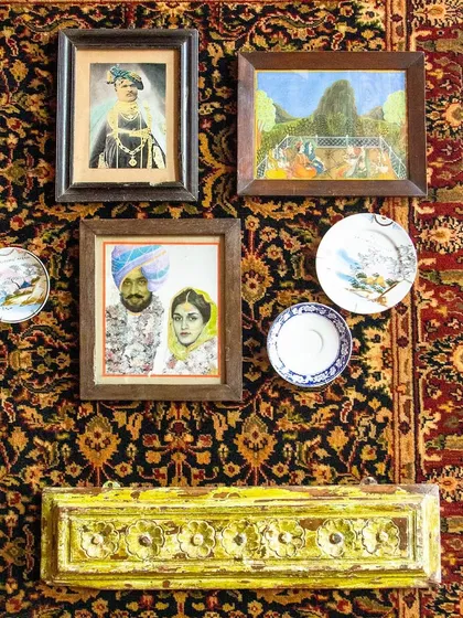 Our walls are a canvas of artistry. This curated collection of portraits and plates, set against a traditional Persian carpet, tells tales of distant lands and eras.
