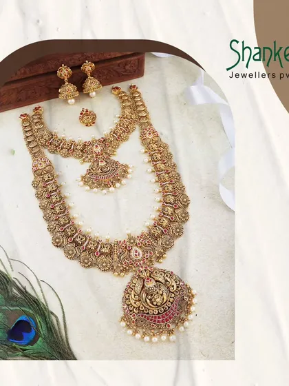 A regal bridal set featuring a large, ornate pendant and matching choker. The intricate detailing and pearl accents highlight the luxury and craftsmanship of our premier wedding collections.
