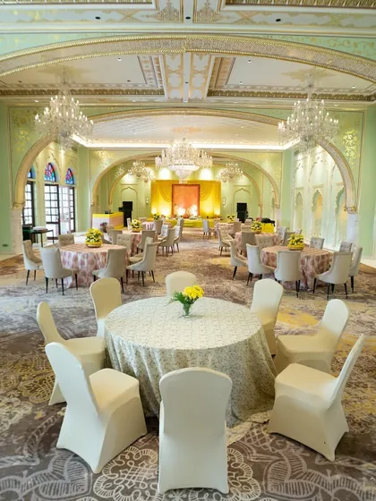 An elegant, pastel green ballroom at the Fairmont Jaipur, with classic European-style architecture and simple, refined table settings.