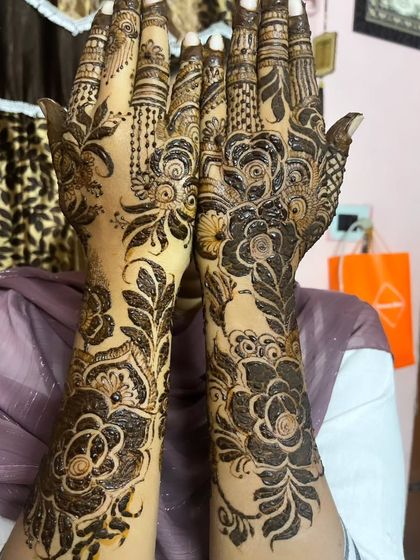 A classic pose to show off the full beauty of this floral henna design.