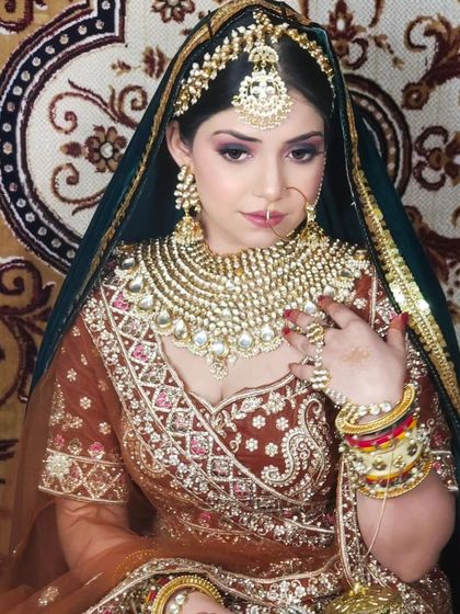 A grand, multi-colored lehenga paired with an equally grand Kundan jewellery set. The intricate bangles complete this maximalist bridal look.