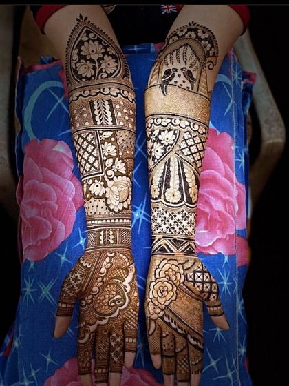 A beautiful example of symmetrical bridal mehndi. Both arms feature a mix of floral, paisley, and bird motifs, creating a harmonious and balanced look.
