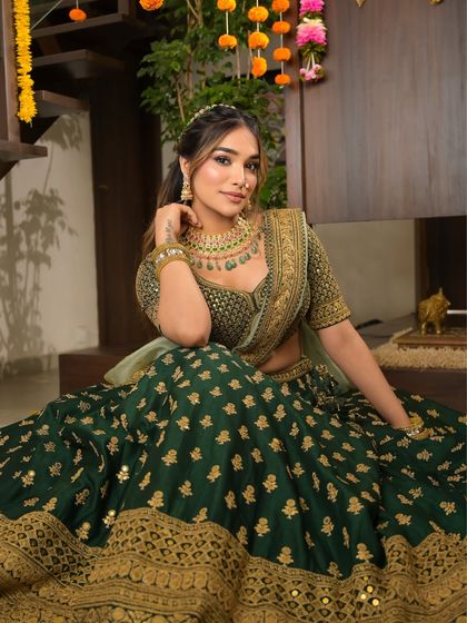 A confident and poised portrait. The deep green lehenga and radiant makeup create a stunning combination that is perfect for any Indian celebration.