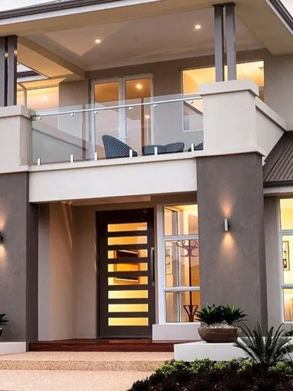 This design for a two-story home features a prominent second-floor balcony with a glass railing, creating an ideal space for outdoor relaxation. The use of contrasting dark and light tones on the facade adds depth and character to the building's exterior.