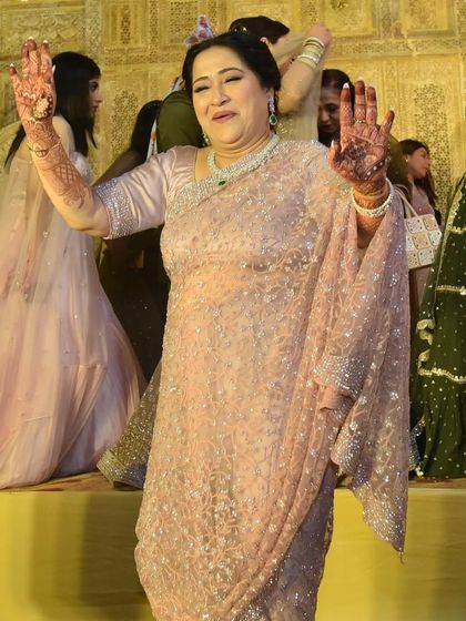 The mother of the bride enjoying the wedding festivities. Her elegant lavender saree and diamond jewelry ensure she looks graceful while being comfortable enough to dance the night away.